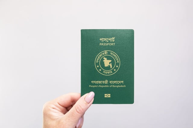 Bangladesh Held Passport In Hand Against A Plain White Background