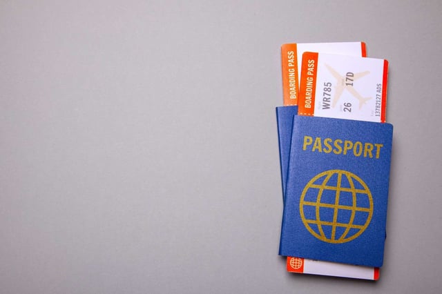 Two Tickets For Plane With Passports On Gray Background