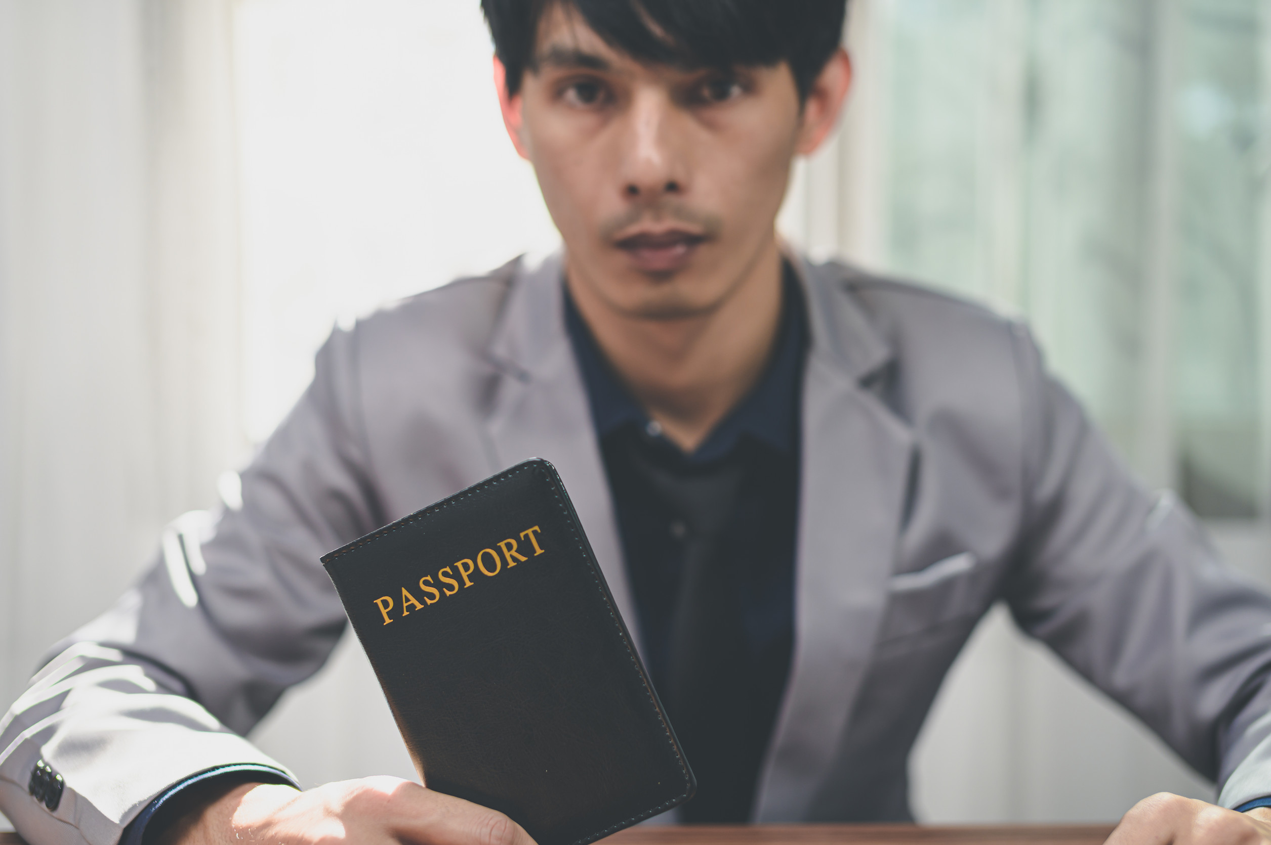 Man In Suit Holding A Passport